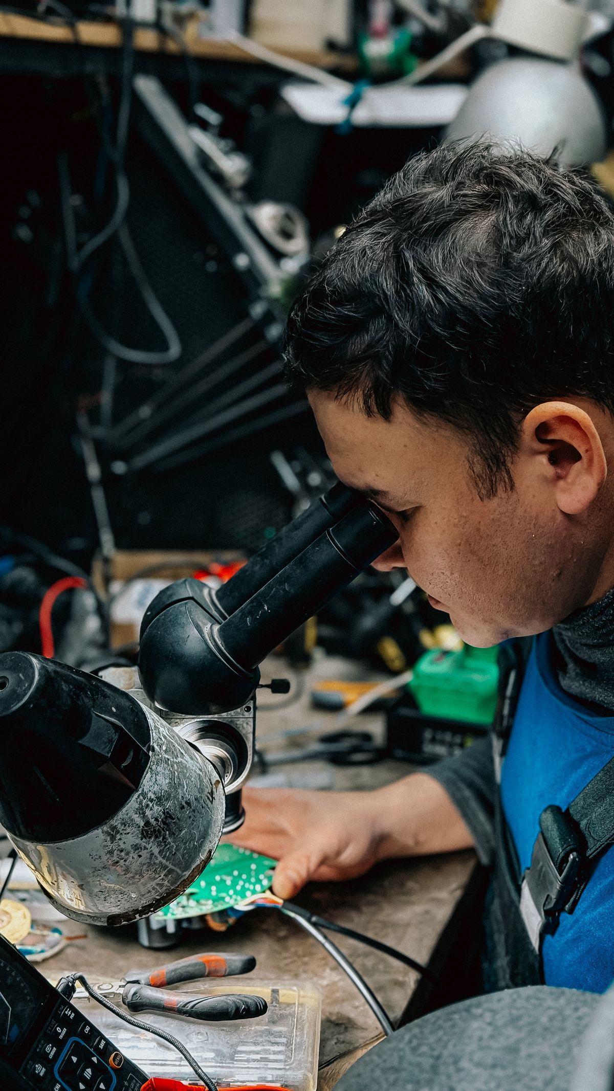 Technician inspecting electronic components through a microscope for quality control